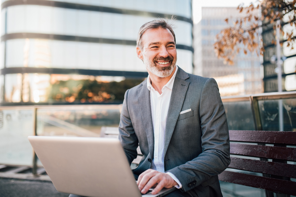 Happy Businessman Using Laptop Outdoors